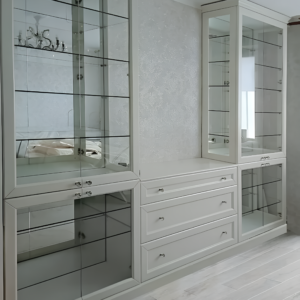 Боковой вид белого шкафа со стеклянными фасадами, видны внутренние полки и конструкция